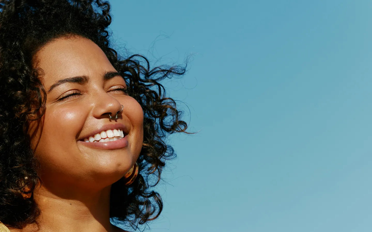 Happy person smiling with blue sky background. Image credit: Natalia Blauth