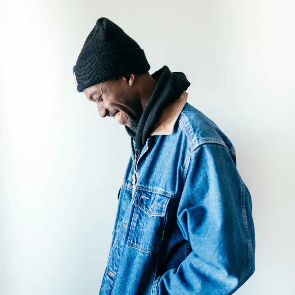 Person wearing a blue denim jacket and black beanie against a white background. Image credit: Brock Wegner