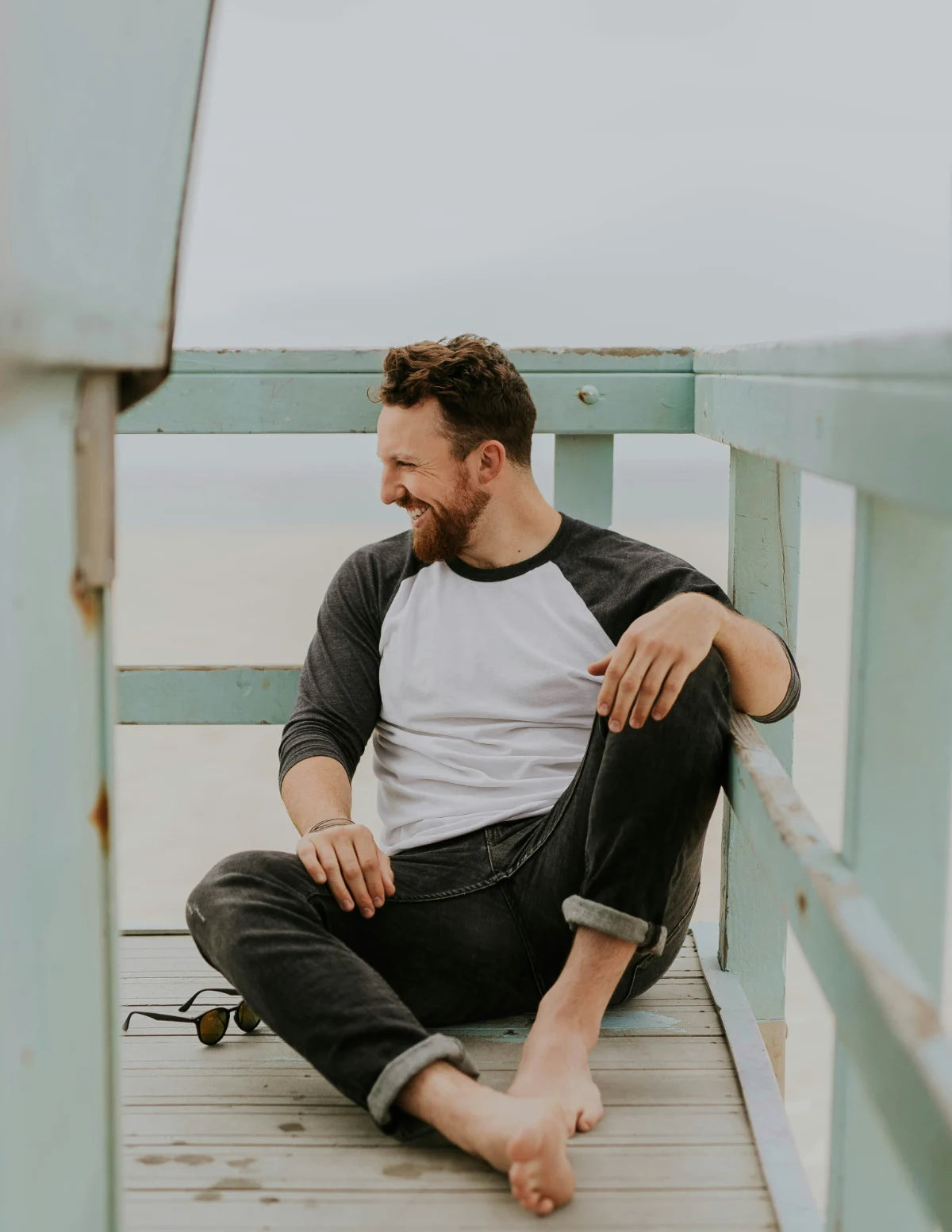 Man sitting on a wooden deck with a casual pose. Image credit: Brooke Cagle