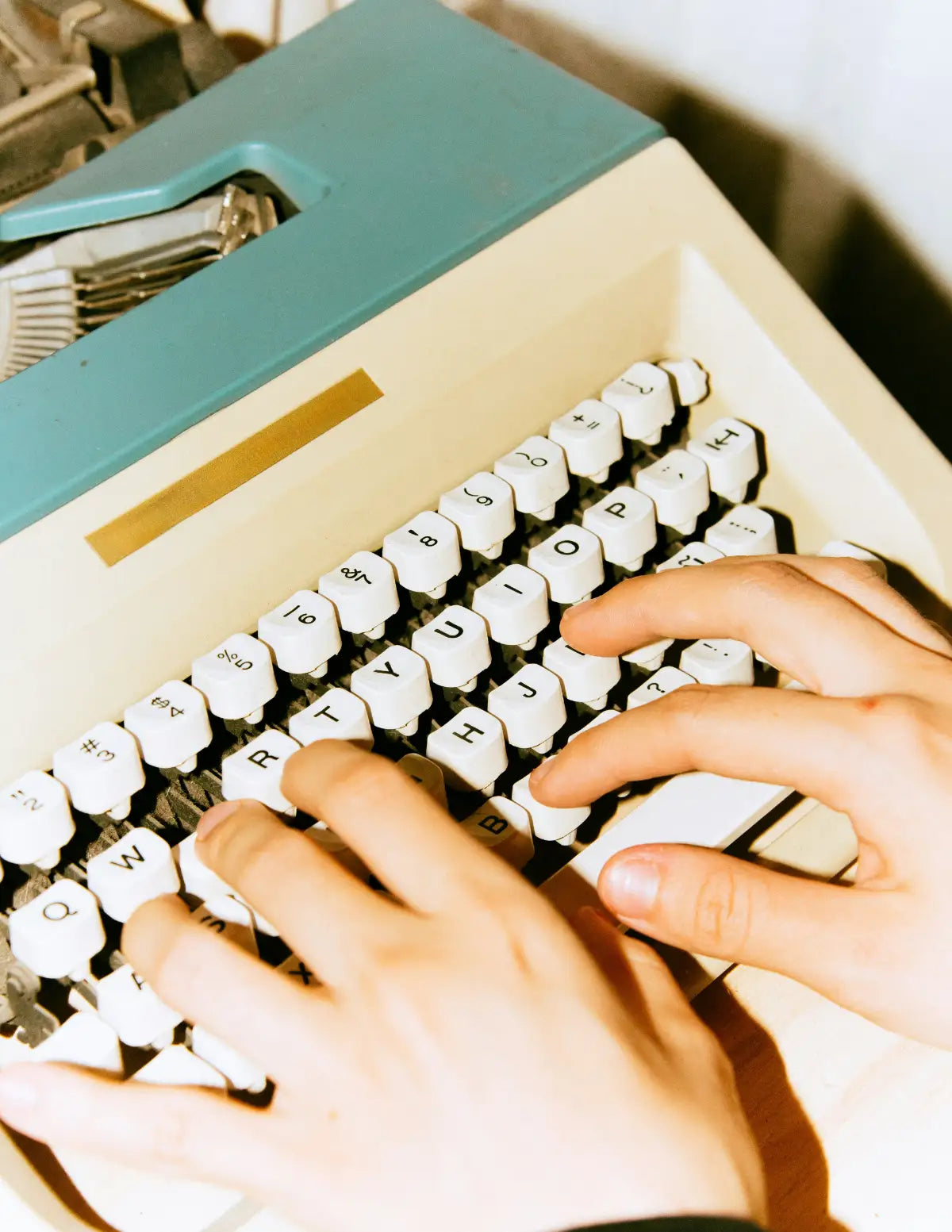 Close-up of hands typing on a vintage typewriter. Image credit: Frank Flores