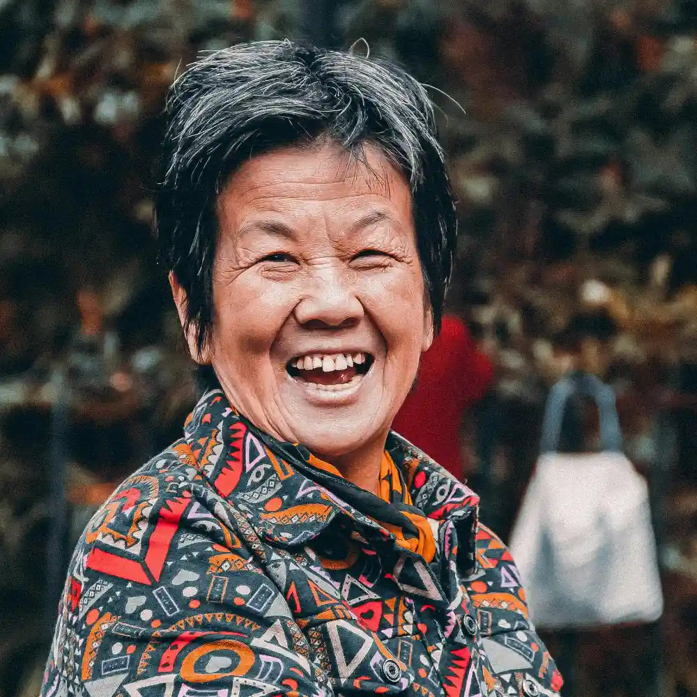Person wearing a colorful patterned jacket with a blurred background. Image credit Maud Beauregard