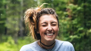 Happy person in woods during rain smiling. Photo credit: Jamie Brown