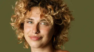 Young person smiling with reen background. Photo credit: Meg Aghamyan