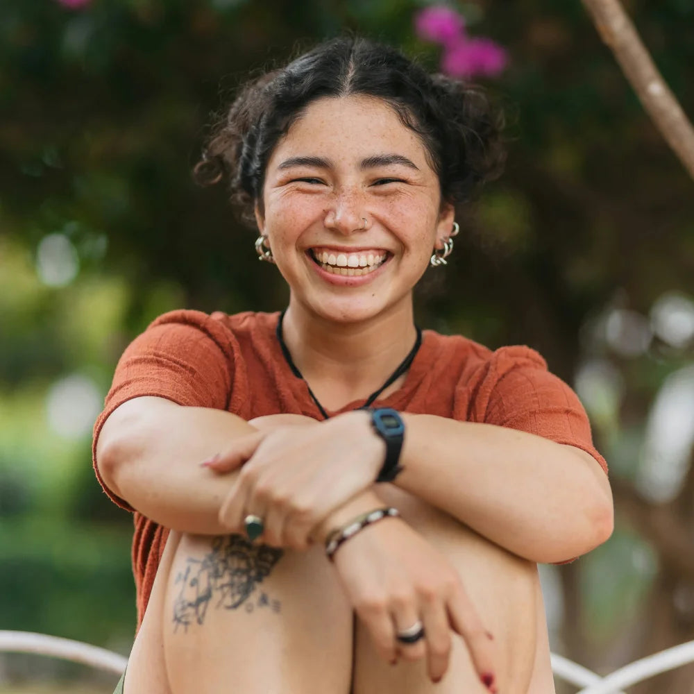 Person wearing a red shirt with a blurred natural background. Photo credit: Jordan Gonzalez